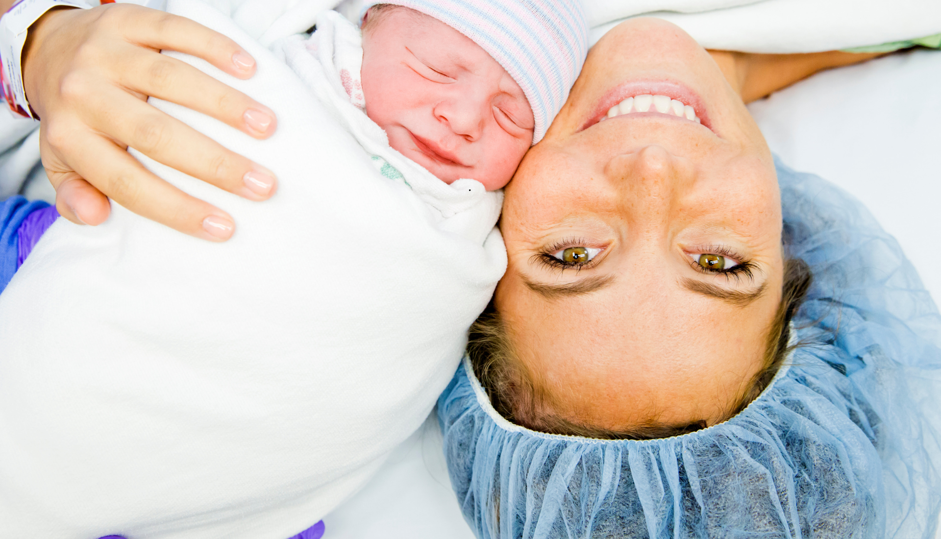 A newborn baby lies with her mother after a C-Section